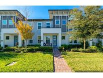 Charming townhome featuring a well-manicured lawn, blue door, and modern architectural details at 5814 Bimini Twist Loop, Orlando, FL 32819