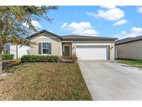 Charming single-story home with a well-manicured lawn and a two-car garage in a suburban neighborhood at 5841 Bullock Pl, St Cloud, FL 34771