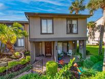 Charming two-story condo featuring a front porch with chairs and lush landscaping, ideal for relaxing outdoors at 668 Lake Villas Dr # 668, Altamonte Springs, FL 32701