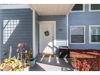 Charming entrance featuring a white door, 'Hello' mat, and potted plants at 729 Secret Harbor Ln # 105, Lake Mary, FL 32746