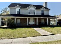 Charming two-story home with a inviting front porch, showcasing its classic architectural design at 1233 Hancock Cir, St Cloud, FL 34769