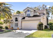 Charming two-story home with a well-manicured lawn, two-car garage, and appealing architectural details at 14266 Squirrel Run, Orlando, FL 32828