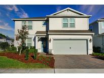 Charming two-story home with a well-maintained lawn, brick driveway, and an attached two-car garage at 2313 Ivy Harvest Pl, Oviedo, FL 32765