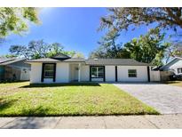 Charming one story home featuring a well-manicured lawn and a paved driveway at 2360 Justy Way, Orlando, FL 32817