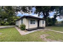 Charming single-story home with a cozy front porch and mature trees providing ample shade at 3440 S Nashville Ave, Orlando, FL 32839