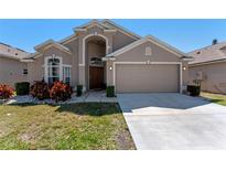 Charming home featuring a two-car garage, manicured lawn, and front garden at 782 Seneca Meadows Rd, Winter Springs, FL 32708
