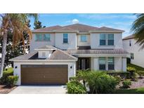 Charming two-story home with a manicured lawn and attached two-car garage at 910 Suffolk Pl, Davenport, FL 33896