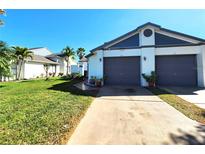 Charming townhouse featuring a well-maintained lawn, neutral exterior, and attached two-car garage at 109 Lakepointe Cir, Kissimmee, FL 34743