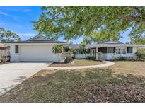 Charming single-story home boasts a two-car garage, fresh exterior paint, and mature landscaping at 116 E Cottesmore Cir, Longwood, FL 32779