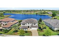 Stunning two-story home with a tile roof, pristine landscaping, and a picturesque waterfront view at 15633 Panther Lake Dr, Winter Garden, FL 34787