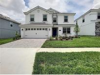 Charming two-story home with a well-manicured lawn, paved driveway and a two car garage at 1673 Moon Valley Dr, Davenport, FL 33896