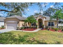 Charming single-story home featuring lush landscaping and a well-manicured lawn, complemented by a two car garage at 1913 Lazy Oaks Loop, St Cloud, FL 34771