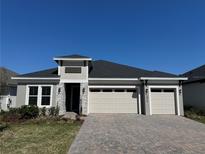 A beautiful single-story home featuring a two-car garage and stone accents and a paver driveway at 2013 Divot Dr, Daytona Beach, FL 32124