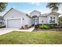 Charming home featuring stone accents, a well-manicured lawn, and an attached two-car garage at 2464 Pawtucket Pass, Mount Dora, FL 32757