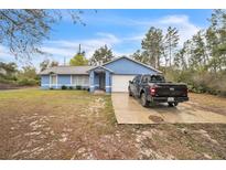 Charming one-story home featuring a well-manicured lawn and a spacious driveway with parking for multiple vehicles at 2935 Apaloosa Trl, Deltona, FL 32738