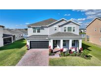 Charming two-story home with well-manicured lawn, brick driveway, and front porch at 5645 Camilla St, St Cloud, FL 34771