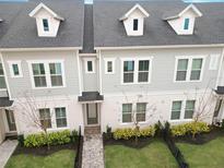 Charming two-story townhome featuring a landscaped front yard, inviting entrance, and dormer windows for added natural light at 936 Wild Date Ln, Lake Mary, FL 32746