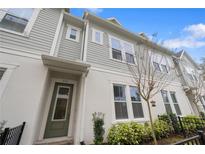 Charming townhouse featuring a quaint green door, light gray siding and welcoming curb appeal at 936 Wild Date Ln, Lake Mary, FL 32746