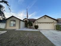 Charming single-story home with a two-car garage and well-maintained landscaping at 117 Anzio Dr, Kissimmee, FL 34758