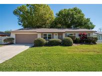 Charming single-story home with a well-manicured lawn and lush landscaping at 129 Coral Bell Ct, Orlando, FL 32807