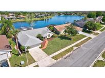 Beautiful single-Gathering home with attached garage, lush lawn and landscaping near a lake at 14772 Eagles Crossing Dr, Orlando, FL 32837