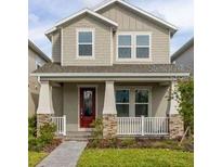 Charming two-story home with a covered porch and manicured lawn showcasing its inviting curb appeal at 16294 Honey Harvest St, Winter Garden, FL 34787