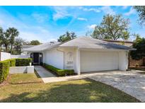 Inviting single-story home featuring a two-car garage, well-manicured lawn, and quaint front entrance under a sunny sky at 250 Cortland Ave, Winter Park, FL 32789