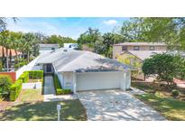 Charming single-story home with a well-manicured lawn, lush landscaping, and a spacious two-car garage at 250 Cortland Ave, Winter Park, FL 32789