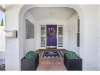 Inviting arched entryway with a vibrant purple front door adorned with a wreath and decorative elements at 250 Cortland Ave, Winter Park, FL 32789