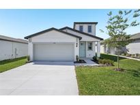 Charming home with a two-car garage, manicured lawn, and a light blue front door at 2518 Linda Knoll Ln, Bartow, FL 33830