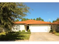 Charming single story home with a well-manicured lawn and an orange tile roof under a blue sky at 2788 Roccella Ct, Kissimmee, FL 34747