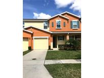 Inviting two-story townhome with vibrant colors, attached garage, and manicured lawn at 5105 Killarney Way, Kissimmee, FL 34746