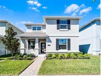 Charming two-story home featuring a well-manicured lawn and a welcoming front porch at 11518 Rhyme Ave, Orlando, FL 32832