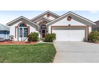 Charming single-story home featuring a well-manicured lawn and an attached two-car garage at 130 Hillside Dr, Davenport, FL 33897