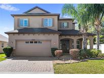 Charming two-story home featuring a two-car garage, landscaped yard, and an inviting front entrance at 15604 Starlite St, Clermont, FL 34714