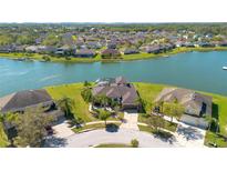 Stunning aerial view of waterfront home with pool, lush landscaping, and serene lake backdrop at 1730 Boat Launch Rd, Kissimmee, FL 34746