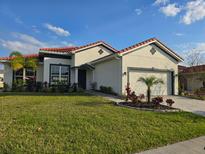 Charming single-story home with a beautiful lawn, tile roof and a well-manicured landscape at 2400 Symphony Cir, St Cloud, FL 34771