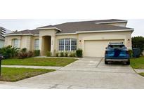 Charming single-story home featuring a well-manicured lawn and an attached two-car garage at 334 Prestwick Dr, Davenport, FL 33897