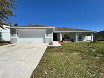 Charming single-story home featuring a two-car garage and a well-manicured front lawn at 110 Evergreen Dr, Auburndale, FL 33823