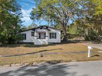 Charming single-story home with a well-maintained lawn, carport, and mature trees at 1208 Bonaire Dr, Leesburg, FL 34748