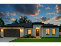 Charming one-story home featuring a two-car garage, manicured lawn, and inviting front entrance at twilight at 16947 Sw 22Nd Terrace Rd, Ocala, FL 34473