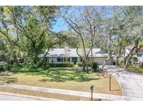 Charming single-story home with a well-manicured lawn and mature trees providing shade at 204 Smokerise Blvd, Longwood, FL 32779