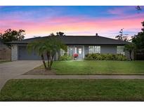 Charming single-story home boasts a well-manicured lawn, gray exterior, and lovely curb appeal at 3132 Nicholson Dr, Winter Park, FL 32792