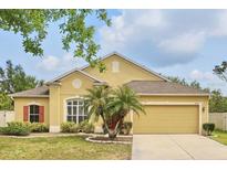 Charming single-Gathering home with well-manicured lawn and tropical landscaping, featuring a two-car garage at 3747 Moon Dancer Pl, St Cloud, FL 34772