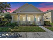 Charming single-story home with a covered front porch, columns, and manicured lawn at 6610 Helston Ln, Windermere, FL 34786