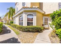 Inviting townhouse featuring a white front door, arched windows, and meticulously maintained landscaping at 698 Seabrook Ct # 103, Altamonte Springs, FL 32714