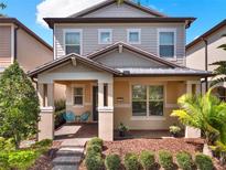 Charming two-story home with a cozy front porch, lush landscaping, and inviting curb appeal at 7166 Enchanted Lake Dr, Winter Garden, FL 34787
