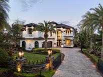 Stunning two-story home featuring manicured landscaping, stone accents, and a circular driveway at 801 W 2Nd Ave, Windermere, FL 34786