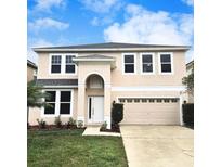 Charming two-story home with a well-maintained lawn, neutral paint, attached garage, and classic architectural details at 10071 Cypress Knee Cir, Orlando, FL 32825