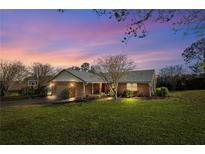 Charming single-story brick home featuring a well-maintained front yard and attached garage in a tranquil neighborhood at 12235 Warren Rd, Clermont, FL 34711